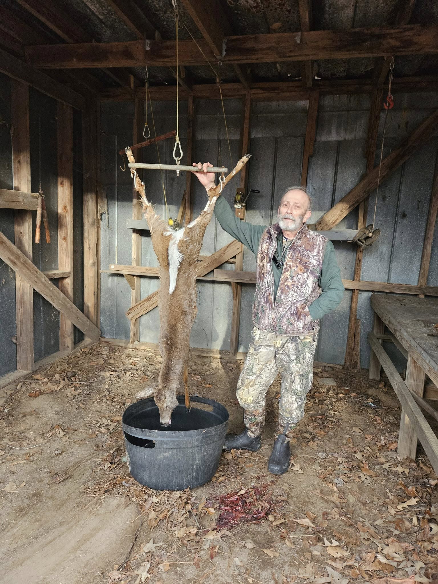 Ed standing with a harvested deer at the skinning shed